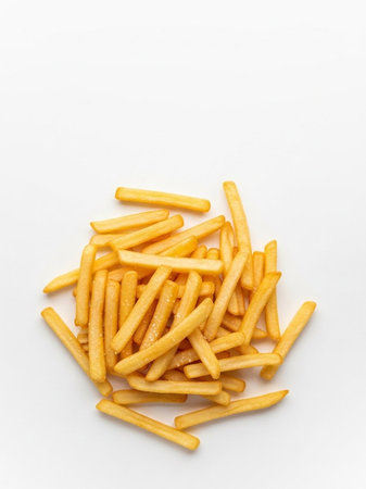 Crispy golden French fries on white background, top view.