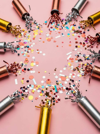 Birthday crackers and confetti on pink background. Top viewの写真素材
