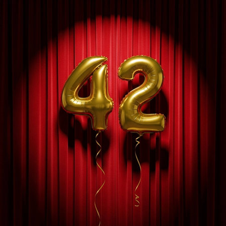 Golden number forty two on red velvet curtain background.Number 42 gold foil balloon with red...