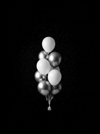 Bunch of black and white balloons on a black background with water drops