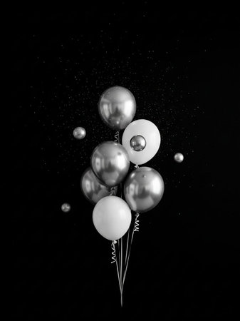 Silver and white balloons on black background. Minimal holiday concept.の写真素材
