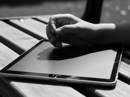 Woman hand using tablet pc on wooden table. Black and white.の写真素材