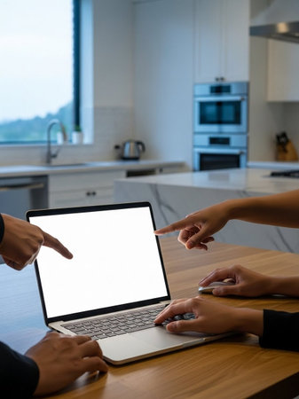 Close up of business people using laptop with blank screen in modern kitchenの写真素材