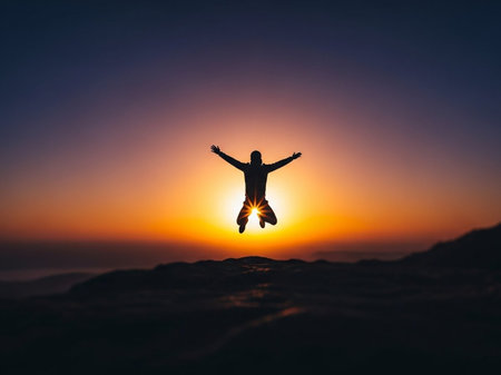 Silhouette of man jumping in the air with sunset sky backgroundの写真素材