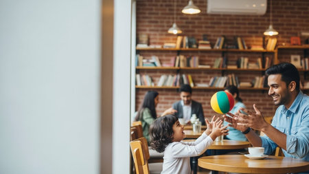 A joyful father plays with his child in a warm coffee shop, surrounded by bookshelves and other patrons, creating a welcoming atmosphere for family bonding and learning.の写真素材