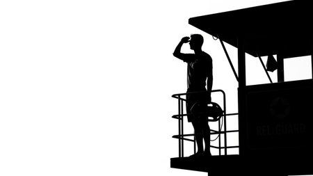 Silhouette of a man with binoculars on lifeguard towerの写真素材