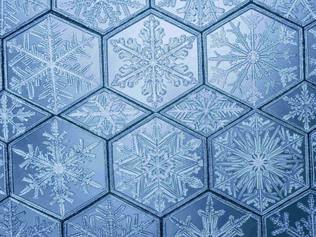 Snowflakes on a blue glass texture background. Close-up.