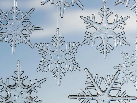 Snowflakes on a window glass against the blue sky. Winter backgroundの写真素材
