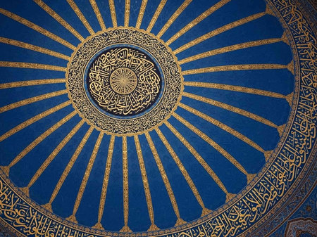 A stunning blue and gold dome with intricate Arabic calligraphy designの写真素材