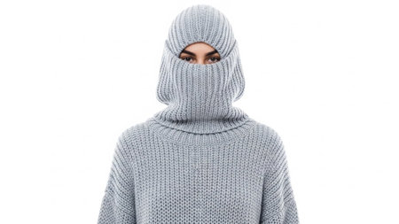 A person wearing a knitted ski mask and sweater on a white backgroundの写真素材