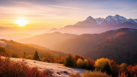 Golden sunrise illuminating autumn mountains and snowy peaksの写真素材