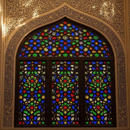 A detailed stained glass window featuring vibrant colors and intricate designs within an ornate arch.の写真素材