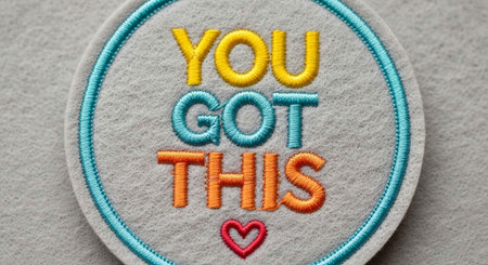 Close-up of a round embroidered patch with colorful text "You Got This" and a heart symbol.の写真素材