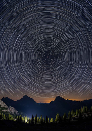 A stunning starry night sky with circular star trails over a mountain landscape