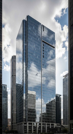 A sleek glass skyscraper stands tall in a bustling cityscape with modern architecture