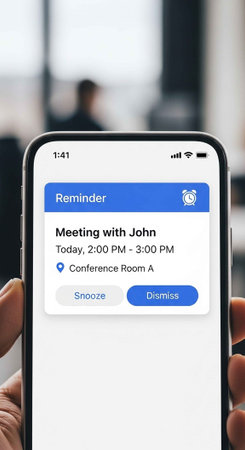 A hand holding a smartphone with a meeting reminder on the screen
