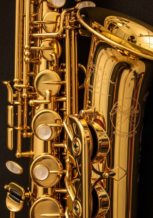 A detailed close-up of a golden saxophone, showcasing its polished body and intricate key...