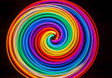 A dynamic spiral of bright, multicolored light trails against a dark background.