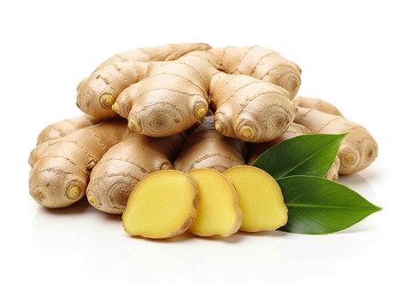 A pile of fresh ginger roots with sliced pieces and green leaves on a white background