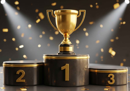 A golden trophy sits atop a podium with numbers 1, 2, and 3 in a spotlightの写真素材