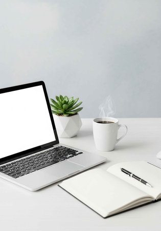 A minimalist workspace with a laptop, notebook, and coffee on a white desk
