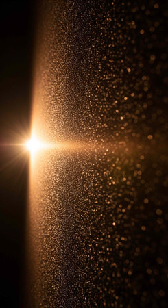 A bright light shines in a dark space with sparkling particles around itの写真素材