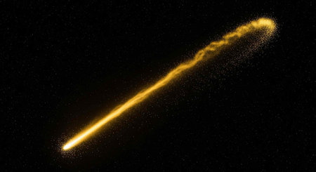 A bright yellow meteor streaks across the dark starry night sky in spaceの写真素材
