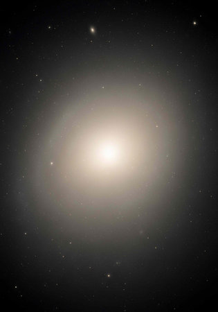 A bright galaxy shines in the darkness of space with stars around itの写真素材