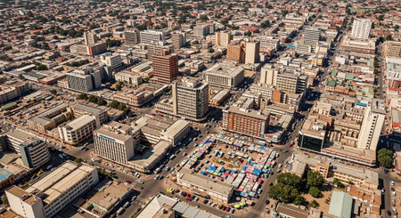 Aerial view of a bustling city with tall buildings and vibrant market stallsの写真素材