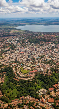 Aerial view of a vibrant city surrounded by lush greenery and a serene lake