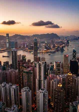Aerial view of a bustling cityscape at sunset with skyscrapers and a serene harborの写真素材