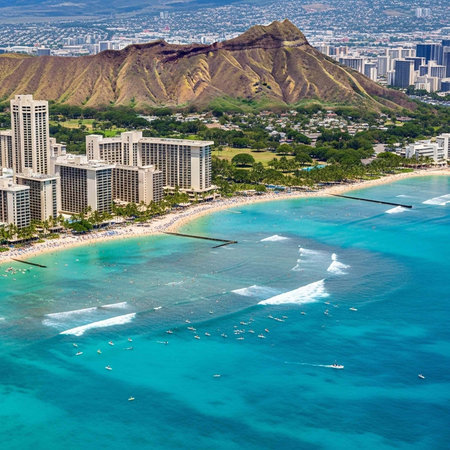 Aerial view of a beautiful beach with hotels and a mountain in the background