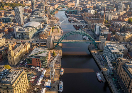 Aerial view of a bustling city with a river and bridge in the centerの写真素材
