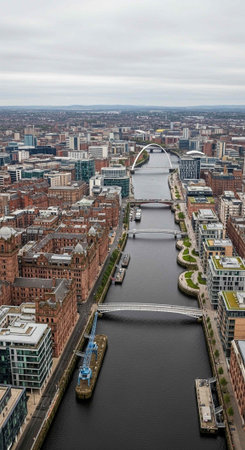 Aerial view of a city with a river and bridge on a cloudy dayの写真素材
