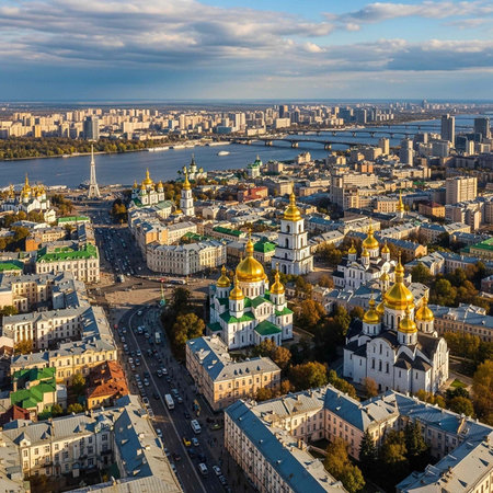 Cityscape with white buildings, green roofs, and gold domes, featuring a river and blue skyの写真素材