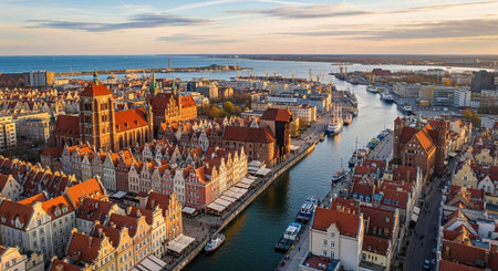 Scenic aerial view of a historic European city with red roofs, a winding waterway, and boats docked...