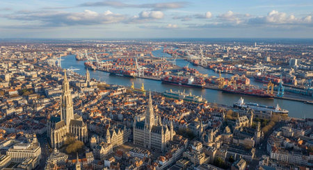 Panoramic aerial view of a city, showcasing a river, historic buildings, and cityscape under a blue sky with clouds.の写真素材