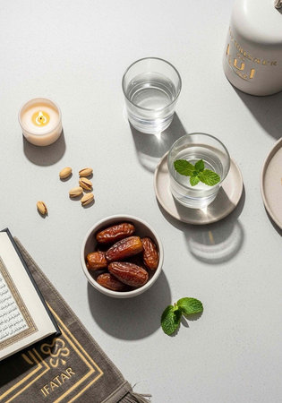 A serene table setting with dates, water, and a book for a peaceful Ramadan iftarの写真素材