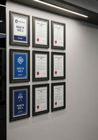A wall with multiple framed certificates and documents hanging in a grid pattern