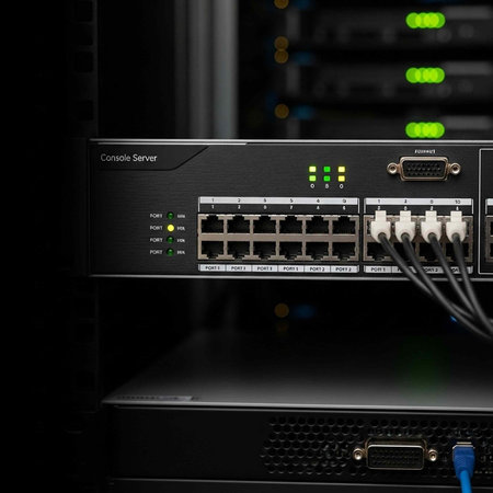 A black console server with various ports and cables in a darkened server room setting
