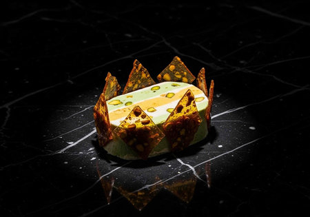 A beautifully presented dessert on a black marble surface with a unique crown-like design