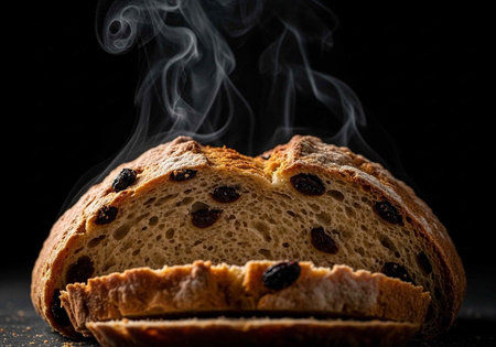 A steaming hot loaf of freshly baked raisin bread on a dark background