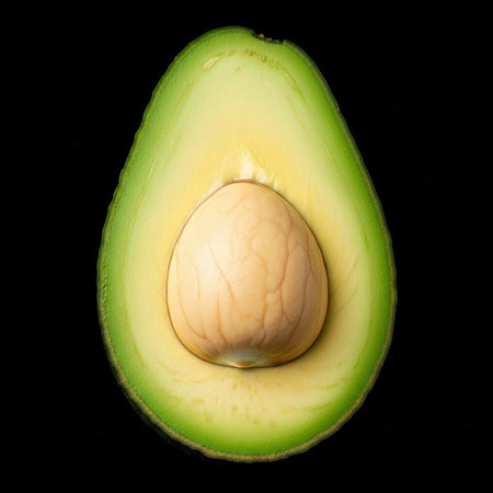 A halved avocado with its pit exposed on a black background