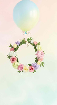 A colorful floral wreath with pastel balloons floating in the air on a soft gradient background