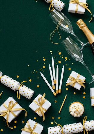 Festive arrangement of gifts, champagne, and cupcakes on a dark green surface