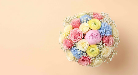 A beautiful bouquet of colorful roses and flowers on a soft peach backgroundの写真素材