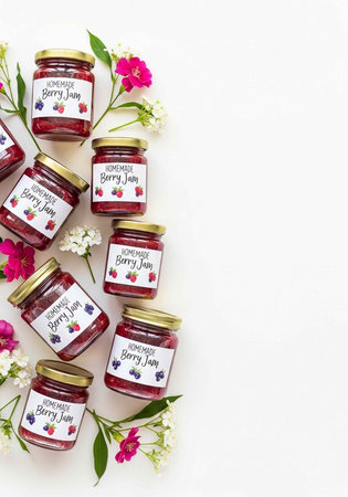 A collection of homemade berry jam jars with flowers on a white background