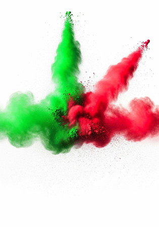 Colorful green and red powder exploding in mid-air against a clean white backdrop