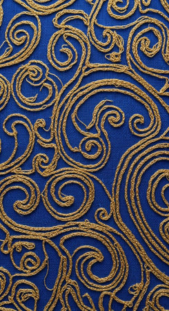 A close-up view of a luxurious blue fabric with intricate golden embroidery patterns