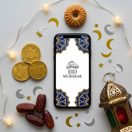 Smartphone with Eid Mubarak message surrounded by festive items like dates, coins, and lantern
